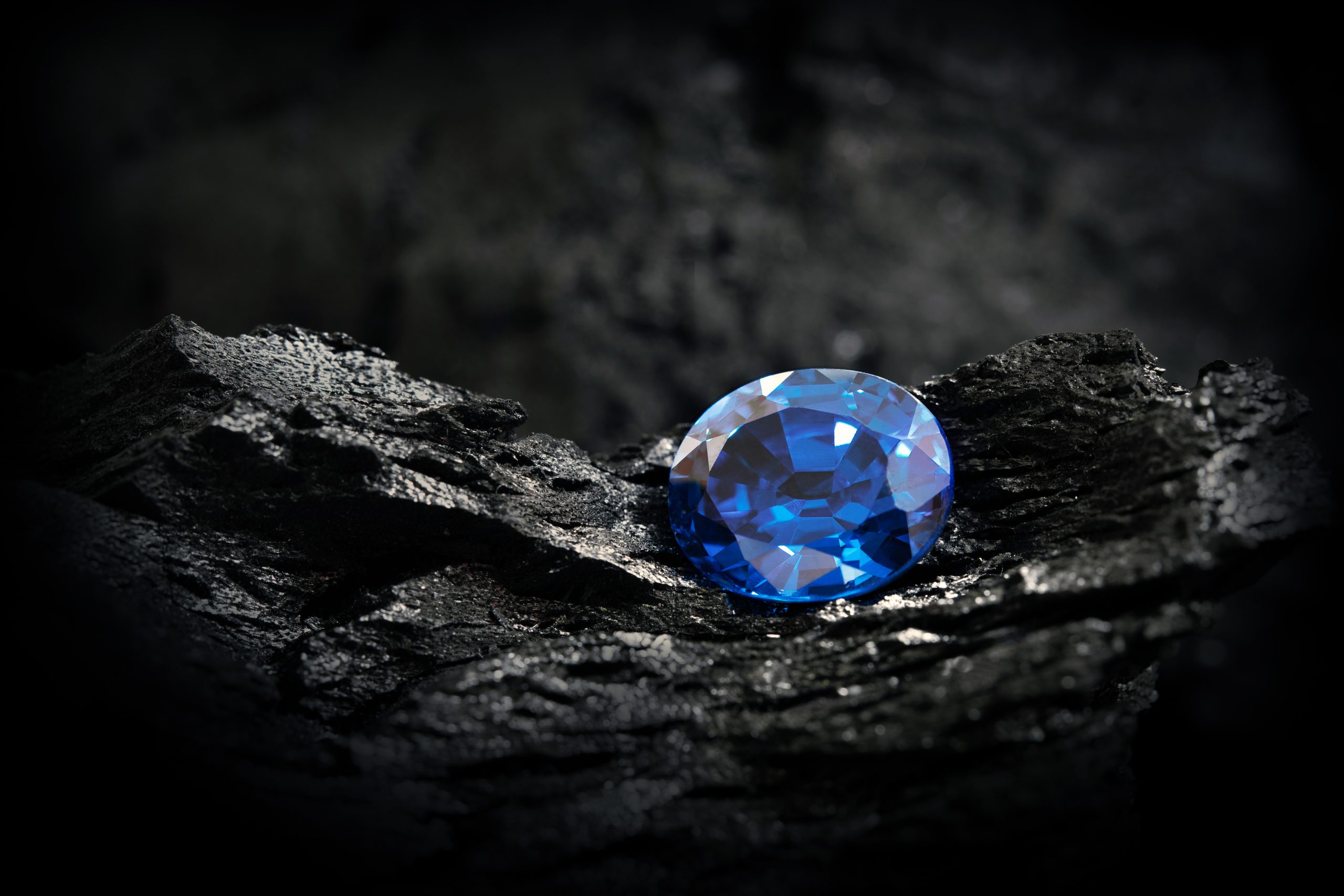 Blue,Sapphire,On,Black,Coal,Background