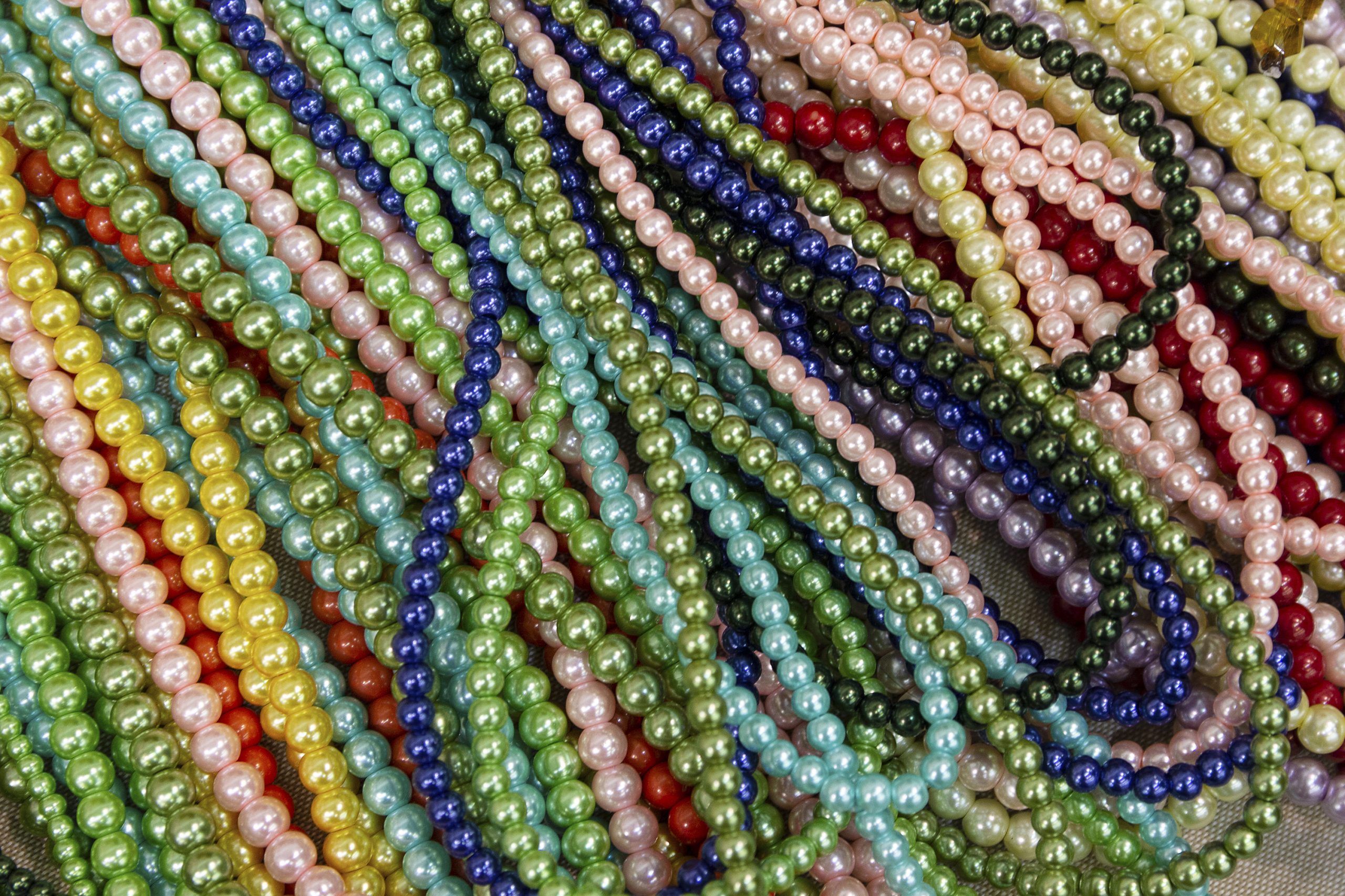 Bright background of handmade strands of colorful beads at outdoor crafts market
